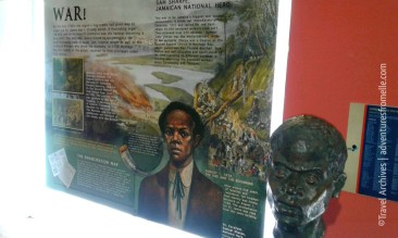 A poster about Sam Sharpe next to his bust